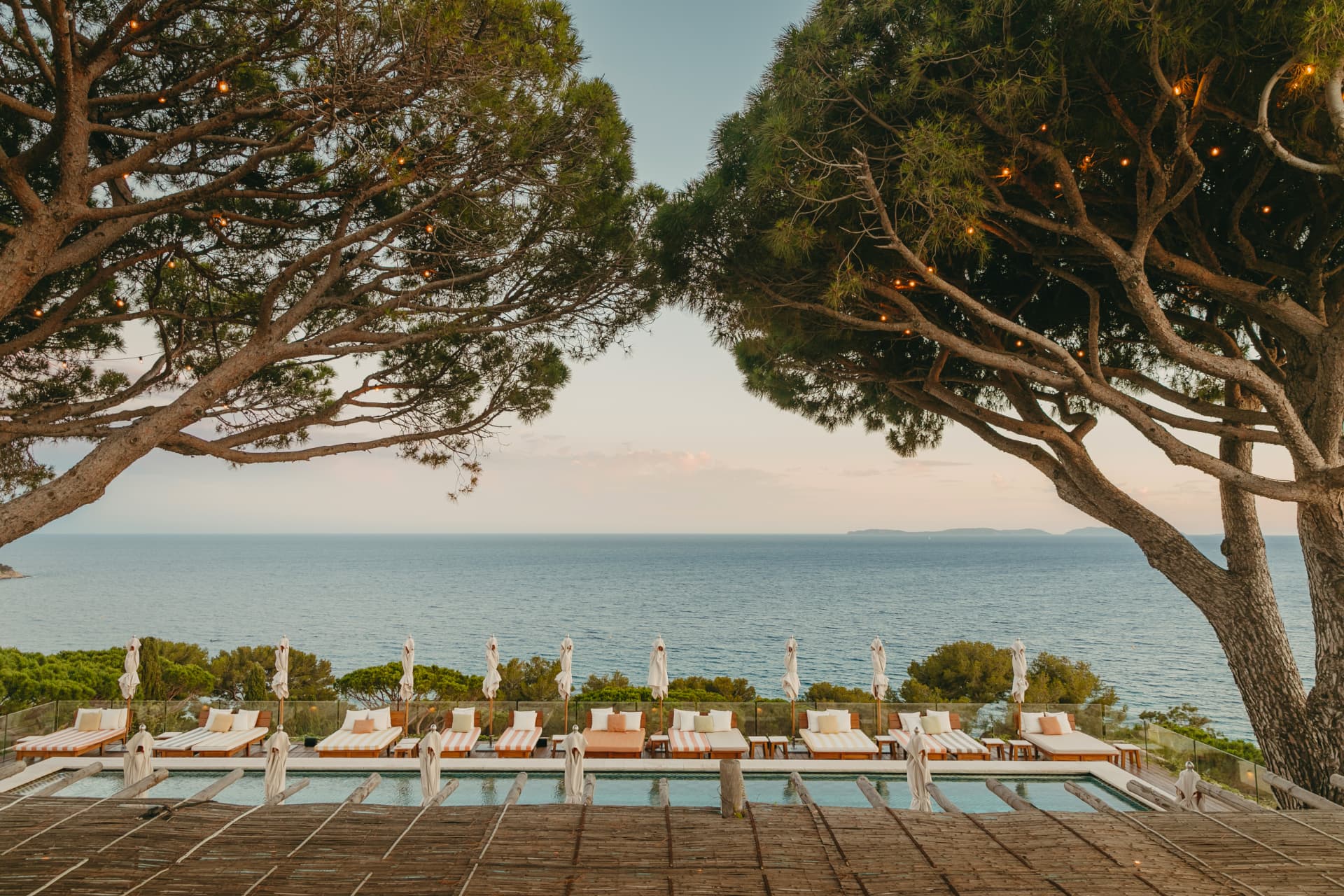 Pool overlooking a Mediterranean bay at golden hour